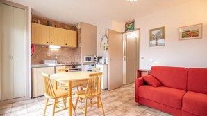 A compact living space with a kitchen, dining area, and a red sofa. - 150m from ski slopes, 1st floor, balcony, tv, ski locker, 29m², Aussois (Aussois)