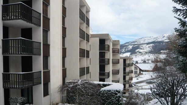 A multi-story building with balconies, surrounded by snow-covered trees and a mountainous backdrop. - 1st floor, balcony, tv, 50m², Villard de Lans (Villard-de-Lans)