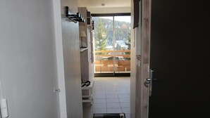 Ein Flur, der zu einem Balkon mit Blick auf einen Wald und einen Fluss führt.