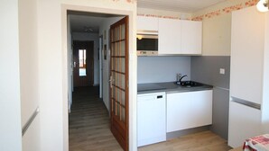 A compact kitchen with white cabinets, a dishwasher, and a microwave. - Ski-in/ski-out & foot of the slopes, 3rd floor, view mountain, balcony, tv, ski locker, 55m² (Auris)