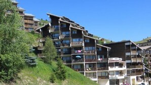 A multi-story hotel with balconies, located on a hillside. - 300m from resort center, 2nd floor, view mountain, balcony, tv, 17m², Auris en Oisans (Auris)