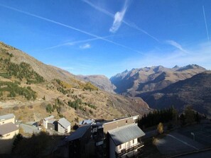 A mountainous landscape with a residential area featuring houses with sloped roofs, a clear sky, and visible power lines. - 10m from ski slopes, 2nd floor, balcony, tv, ski locker, 23m², Auris en Oisans (Auris)