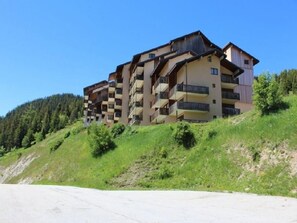 A multi-story hotel with balconies, situated on a hillside with a clear sky. - 10m from ski slopes, 2nd floor, balcony, tv, ski locker, 23m², Auris en Oisans (Auris)