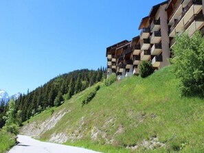 A hillside hotel with multiple balconies and a clear sky.