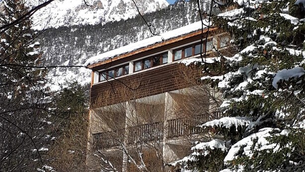 A building with a wooden facade and a balcony overlooking a snowy landscape with mountains in the background. - 100m from ski slopes, balcony, parking, tv, ski locker, 30m², Ceillac en Queyras (Ceillac)
