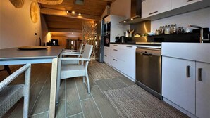 Une cuisine moderne avec des meubles blancs, des appareils en acier inoxydable et des meubles en osier.
