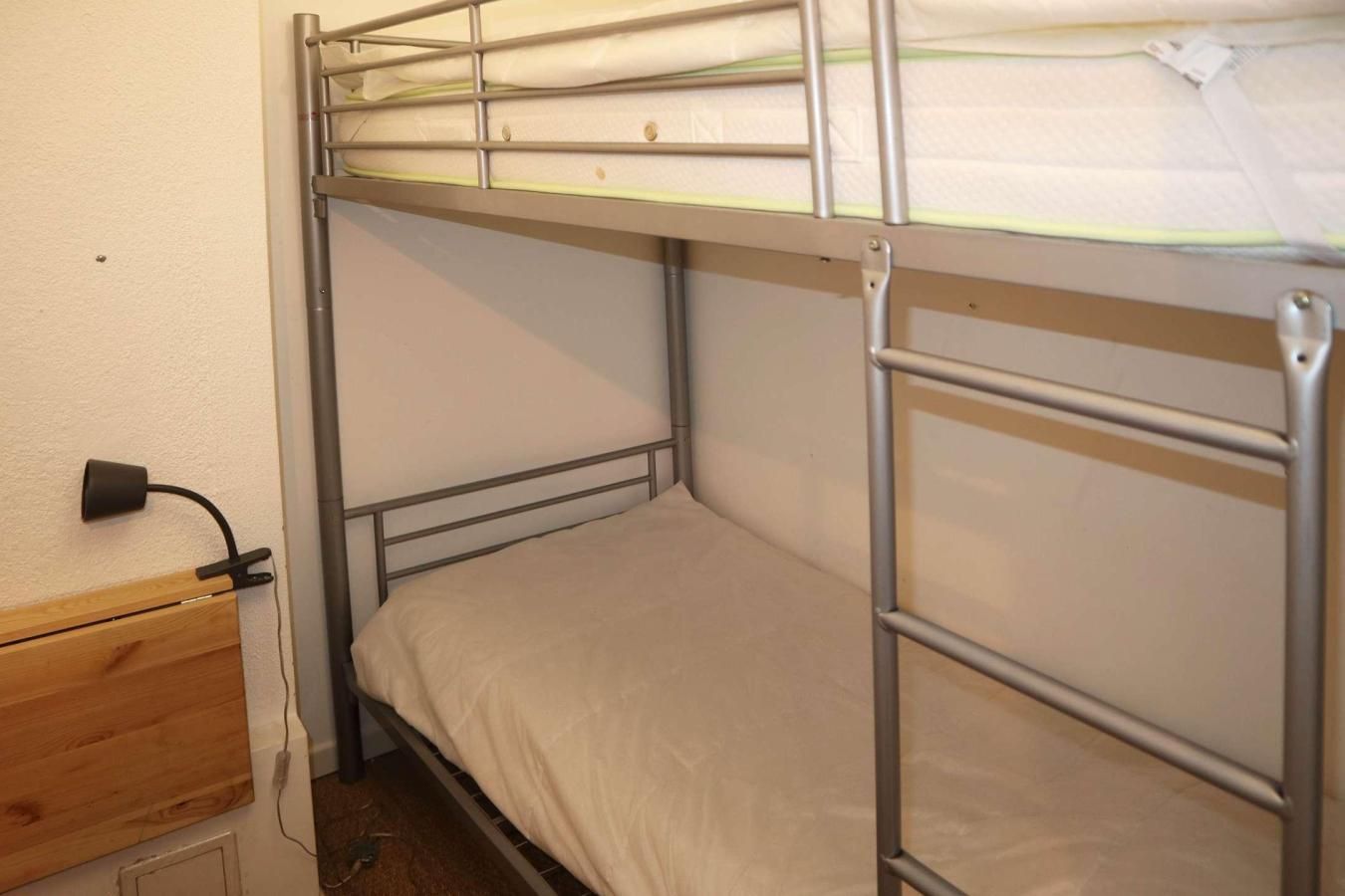 A bunk bed with metal railings and a wooden headboard.