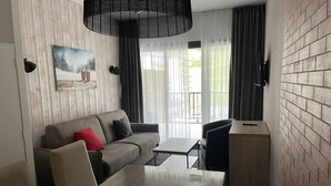 Een moderne kamer met een bank, een eettafel en een klein kastje.