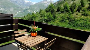 A wooden table and bench on an outdoor balcony with a mountain view. - 1st floor, balcony, tv, ski locker, 58m², Tignes (Tignes)