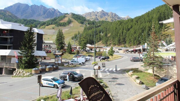 A mountain town with a ski shop, a parking lot, and a view of the mountains. - Resort center, 1st floor, balcony, tv, 30m², Vars (Vars)
