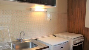 A compact kitchen with a sink, a small refrigerator, and a stove. - Resort center, 1st floor, balcony, tv, 30m², Vars (Vars)