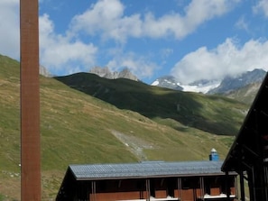 A mountain lodge with a metal roof, wooden walls, and a view of snow-capped peaks. - 100m from resort center, 4th floor, balcony, tv, ski locker, 17m², Tignes (Tignes)
