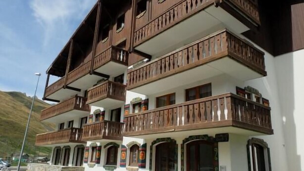 Un immeuble à plusieurs étages doté de balcons en bois et de fenêtres en arc de cercle.