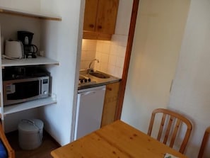 A compact kitchen with a microwave, coffee maker, sink, and a small refrigerator. - 100m from resort center, 4th floor, balcony, tv, ski locker, 17m², Tignes (Tignes)