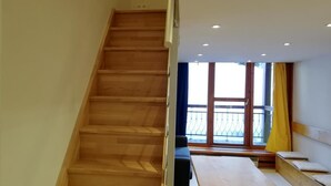 Eine Holztreppe führt zu einem Balkon mit Aussicht.