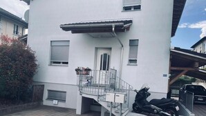 A modern two-story building with a metal staircase leading to a small balcony. - 2 bedroom apartment in lower morbio (Morbio Inferiore)