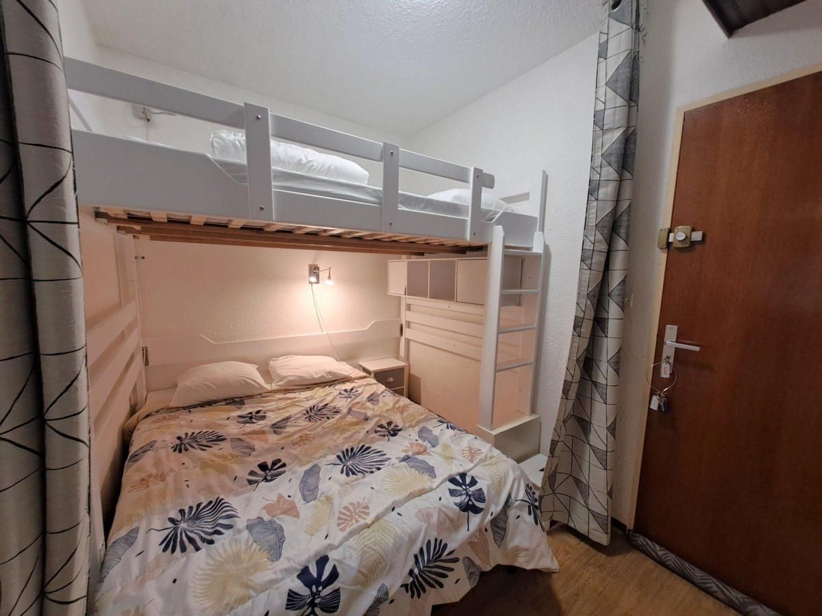 Una camera con un letto a castello, un comodino e una porta in legno.
