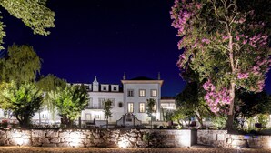 A historic building with a stone wall in front, surrounded by trees and a night sky. - Valverde Santar Hotel & Spa – Relais & Châteaux (Nelas)