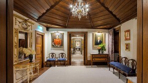 A grand hallway with wooden paneling, a chandelier, and classical decor including paintings and furniture. - Valverde Santar Hotel & Spa – Relais & Châteaux (Nelas)