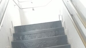 En trappe i mørkegrå med gelænder på højre side, der fører opad.