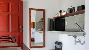 A compact kitchen with a microwave, sink, and a small trash bin. - Apartamento 22 (Bacalar)