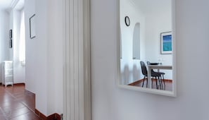 Um corredor com área de refeições, um radiador e um quadro pendurado na parede.