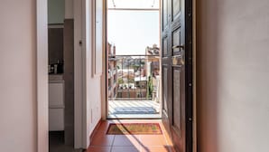 A narrow hallway leading to a balcony with a view of neighboring buildings. - Italianway - Cristoforo Colombo 5B (Milan)
