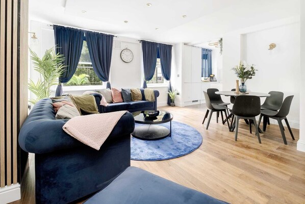 Relax in this stylish living space with a comfortable sofa, coffee table, and dining area.