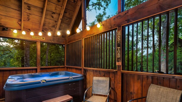 Una terrazza in legno con una vasca idromassaggio, due sedie e un cartello con scritto 'HOT TUB'.