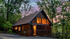 Una baita di legno con tetto spiovente, ampie finestre e un ingresso accogliente.