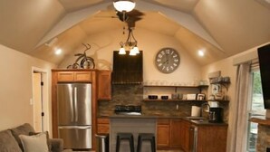 A compact living space with a kitchenette, a dining area, and a seating area. - Hidden Gem Cottages (Palestine)
