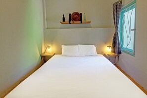 Relax in comfort with a large bed, bedside tables, and a convenient shelf above.