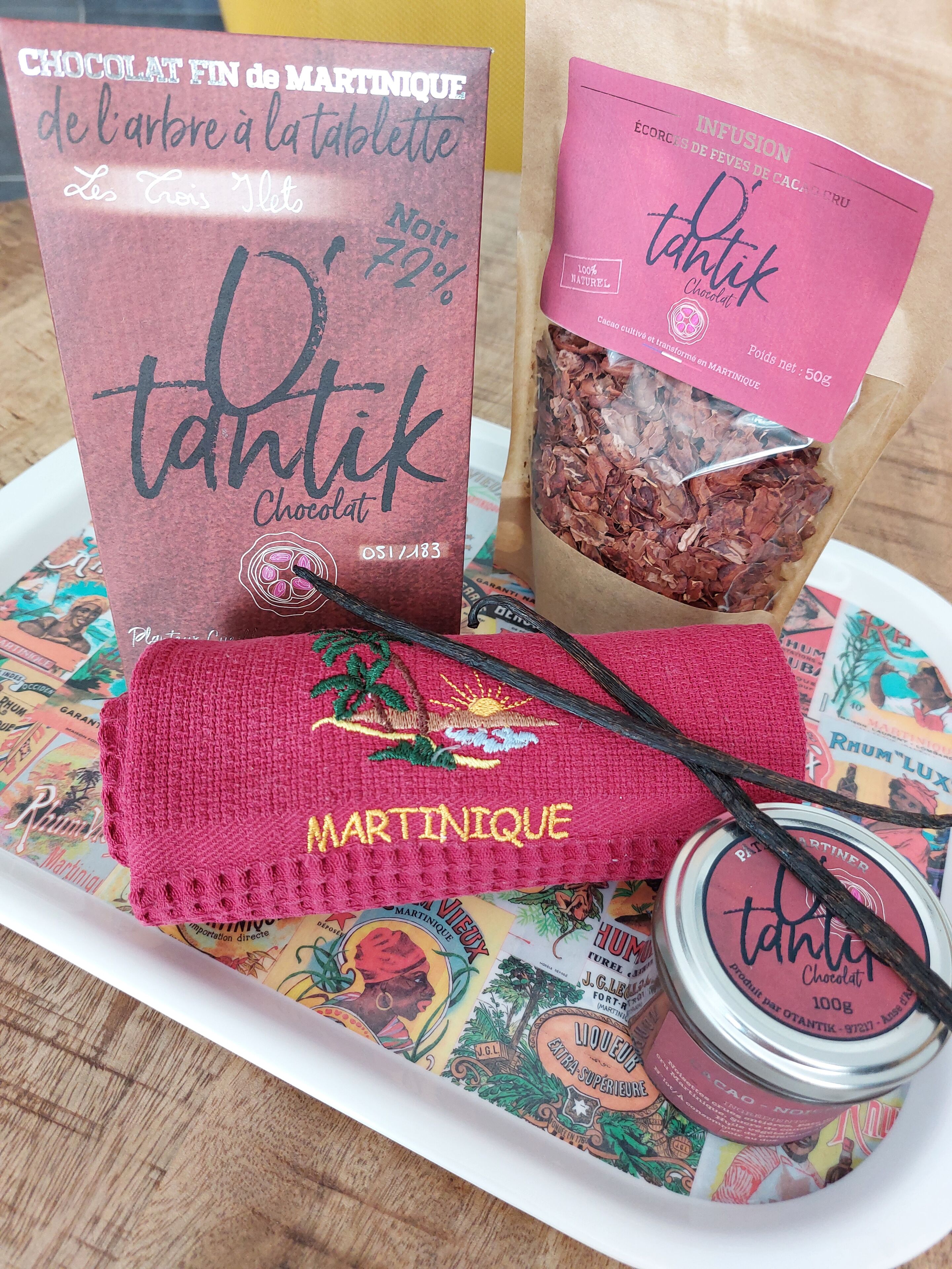 Un vassoio con un prodotto al cioccolato, un panno rosa ricamato e un barattolo di cioccolato.