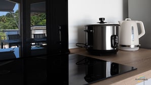 A modern kitchen with a stainless steel slow cooker and a white electric kettle on a wooden countertop. - L'anse Plage. Situation Géographique Idéale (L'anse a l'âne)