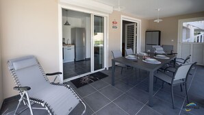 A modern outdoor dining area with a table set for four, surrounded by chairs. - L'anse Plage. Situation Géographique Idéale (L'anse a l'âne)