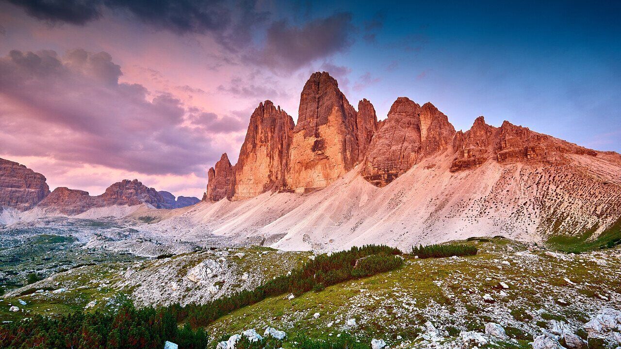 A mountainous landscape with prominent rock formations and a valley.