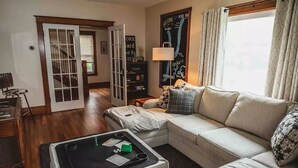A living room with a sofa, a coffee table, and a bookshelf. - Keuka Village House, Penn Yan
 (Penn Yan)