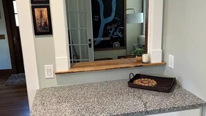 A kitchen with white cabinetry, a granite countertop, and a chalkboard sign above the sink. - Keuka Village House, Penn Yan
 (Penn Yan)