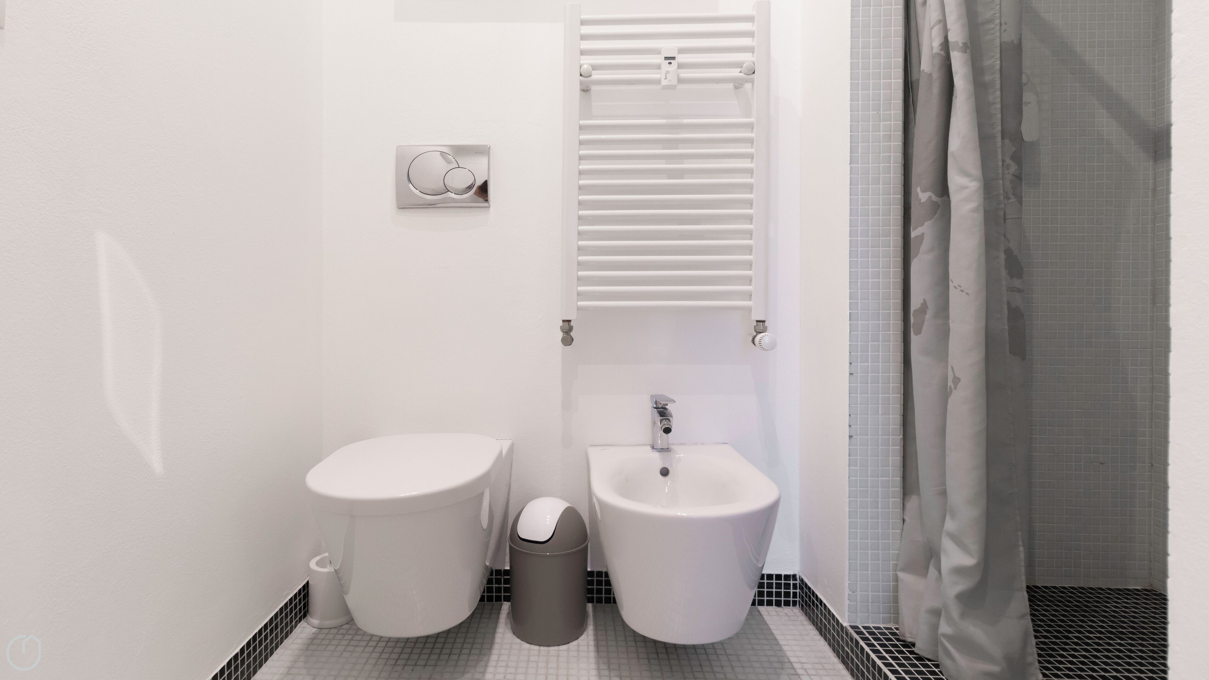 A bathroom with a toilet, bidet, and sink.