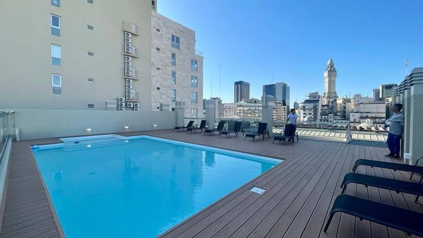 A rooftop pool with lounge chairs and a city view. - Studio In San Telmo- Paseo De La Cisterna- 529 (Buenos Aires)
