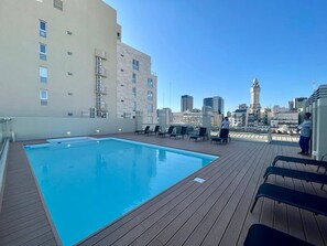 A rooftop pool with lounge chairs and a city view. - Studio In San Telmo- Paseo De La Cisterna- 529 (Buenos Aires)