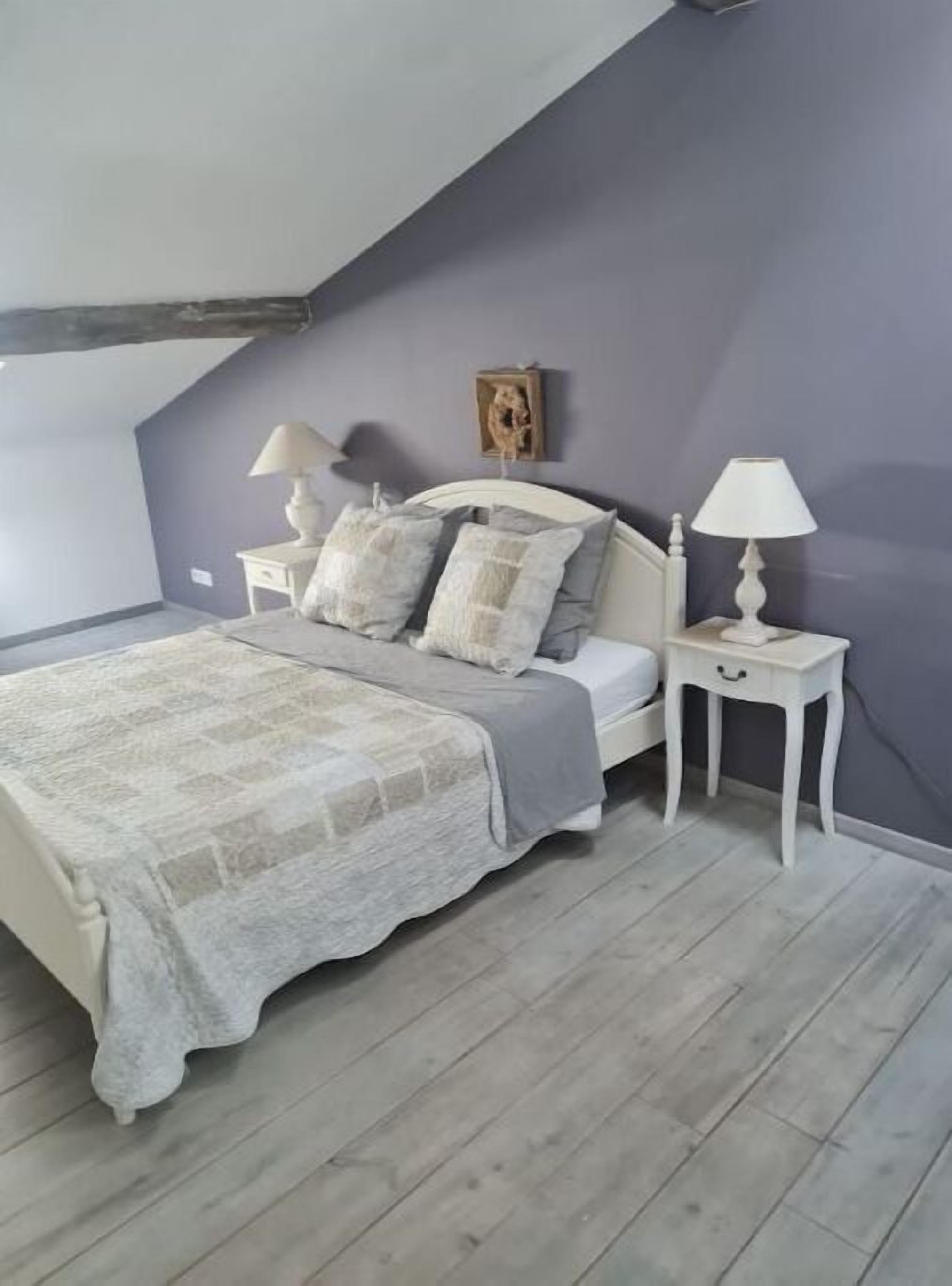 A bedroom with a bed, two bedside tables, and a nightstand.