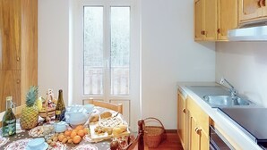 Une cuisine avec des meubles en bois, un évier en acier inoxydable et une fenêtre à vitre dépolie.