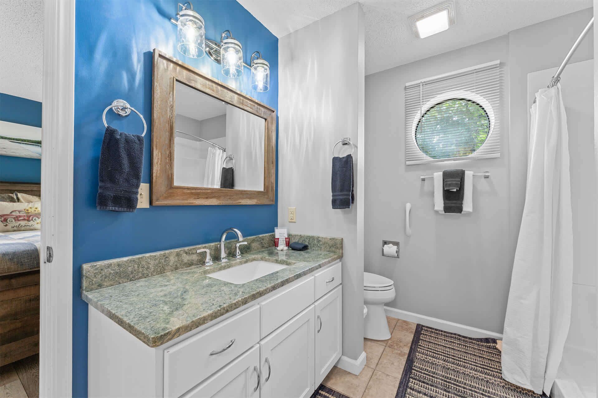 A bathroom with a sink, mirror, and toilet.