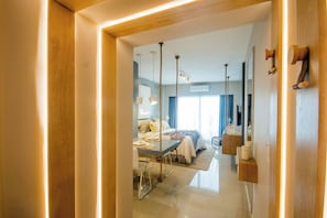 A modern hotel room with a bed, bedside table, and a view of the hallway. - Luxurious Studio in San Telmo (Buenos Aires)