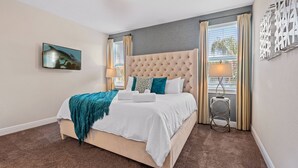 A bedroom with a large bed, a television on the wall, and a window with curtains. - AMAZING 8 BEDROOMS WITH POOL AND GAME ROOM PERFECT LOCATION! (2308) (Kissimmee)