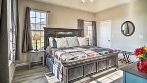 A bedroom with a wooden bed, a nightstand, a dresser, a ceiling fan, and a window with curtains. - Charming Family Country Lane Cottage| 3 min to lake (Dandridge)