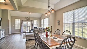 A spacious dining area with a wooden table and chairs, large windows, and a view of the outdoors. - Charming Family Country Lane Cottage| 3 min to lake (Dandridge)
