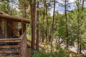 A wooden cabin with a deck, surrounded by tall pine trees. - Luna Bella Hideaway Cabin, 2 bedroom, 1 bath in Ruidoso (Ruidoso)