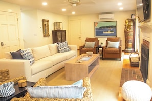 A living room with a sofa, armchairs, a coffee table, and a fireplace. - 6 bedroom beach house steps from Goose Rocks Beach!  (Kennebunkport)